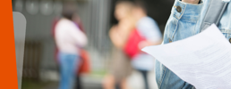 Close-up of a student holding results paper.